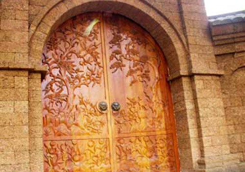 Cánh cổng được làm từ gỗ mít tôn thêm sắc vàng cho chiếc cổng.